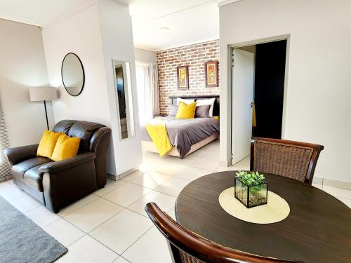 uma sala de estar com uma mesa e uma cama em Luxury Lowveld Apartment em Nelspruit