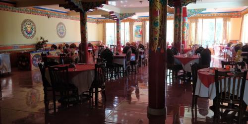 a restaurant with tables and chairs with people sitting at them at The Druk Ladakh in Leh