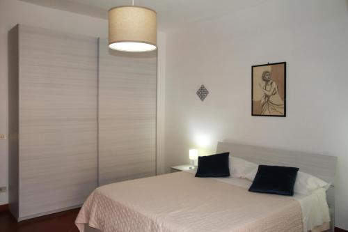 1 dormitorio con cama blanca y almohadas negras en Attico vista mare con terrazza e spa riscaldata, en Santo Stefano di Camastra