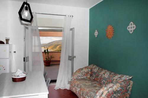 sala de estar con sofá y silla en Attico vista mare con terrazza e spa riscaldata, en Santo Stefano di Camastra