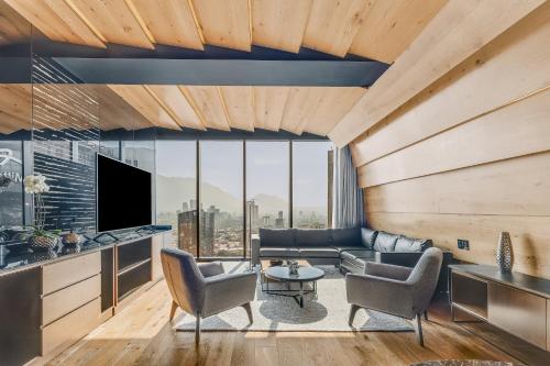 a living room with a couch and a tv at Live Aqua Monterrey in Monterrey