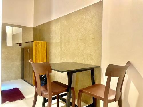 uma cozinha com uma mesa e duas cadeiras em Reach Residency em Cochin