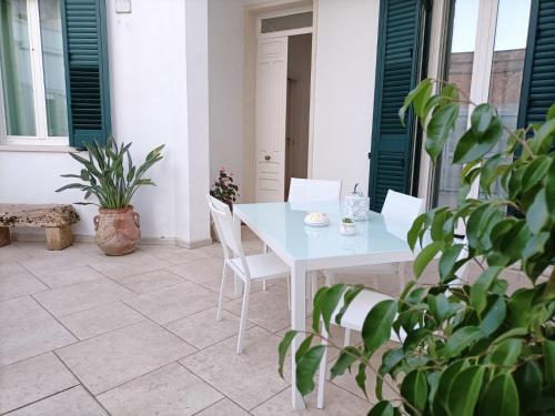 Il ponte sul Salento في Trepuzzi: طاولة بيضاء وكراسي على فناء به نباتات