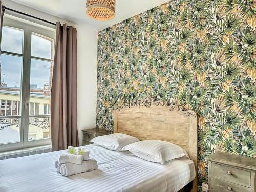 1 dormitorio con 1 cama grande y papel pintado tropical en Villa Victoria YourHostHelper en Deauville
