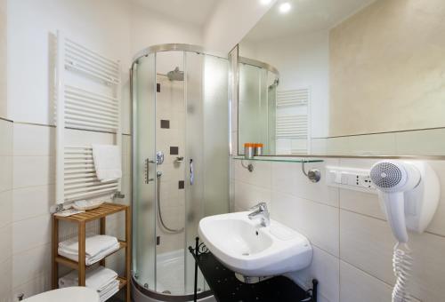 ein weißes Bad mit einem Waschbecken und einer Dusche in der Unterkunft Alba Romana in Rom