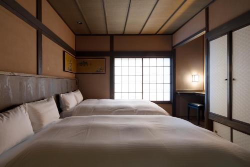 una camera con due letti e una finestra di Yasakahan a Kyoto