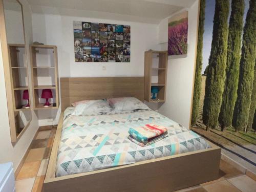 um pequeno quarto com uma cama com duas almofadas em La Rabasse de Gallinette em Aups