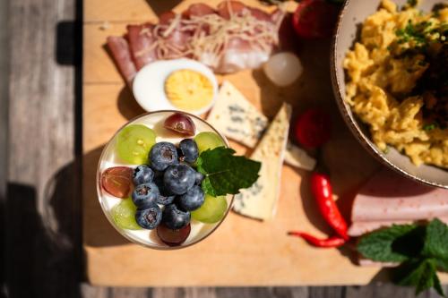 a bowl of fruit on a cutting board with a plate of food at Hotel Krimmlerfälle in Krimml
