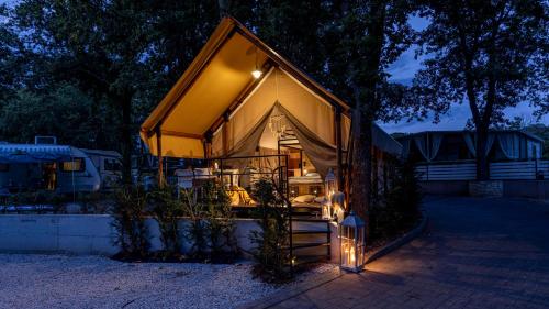 a small house with a tent with lights on it at Polidor Glamping Resort in Poreč