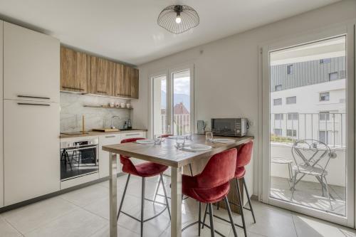 une cuisine avec une table et des chaises rouges ainsi qu'une fenêtre dans l'établissement View Point beach, à Annecy