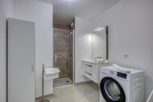 une machine à laver dans une salle de bain avec douche dans l'établissement View Point beach, à Annecy