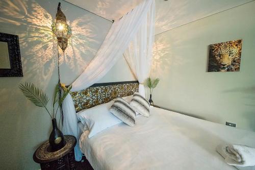 a bedroom with a bed with white sheets and pillows at ZANZIBAR FANTASTIC 1 Bedroom APARTMENT in Gold Coast