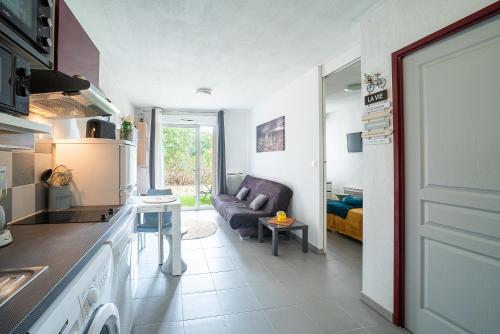 une cuisine et un salon avec un canapé dans l'établissement Soleil sur la Massane - Appartement avec terrasse, à Argelès-sur-Mer