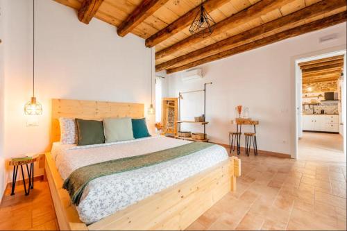 a bedroom with a large bed and wooden ceilings at Casa Nostra - Garda Rooms in Cavalcaselle