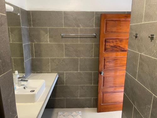 ein Bad mit einem Waschbecken und einer Dusche in der Unterkunft Villa Ura in Uturoa