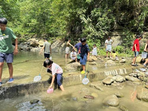 eine Gruppe von Menschen, die im Wasser spielen in der Unterkunft De Wang Villa in Meinong