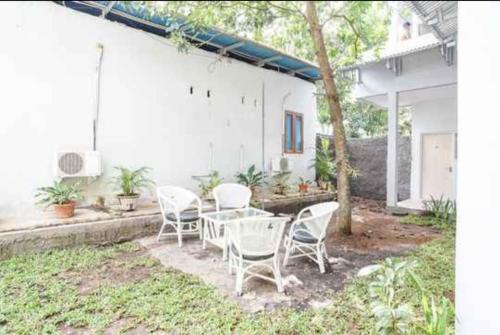 a group of chairs and a table in a yard at PAS Residence Sam Ratulangi Airport Mitra RedDoorz in Mapanget
