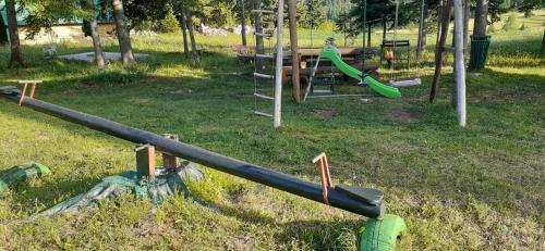 an empty playground with a slide in a park at Eco Village Podgora Household Kaljevic in Žabljak