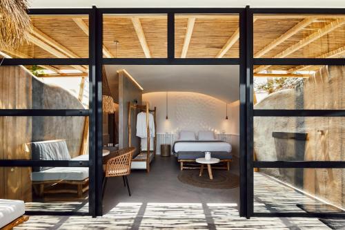 ein Schlafzimmer mit einem Bett in einem Zimmer in der Unterkunft Oscar Beachfront Suites - Adults Only in Perivolos