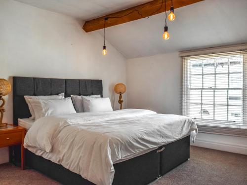 a bedroom with a large bed and two windows at Waterloo Sunset in Bootle