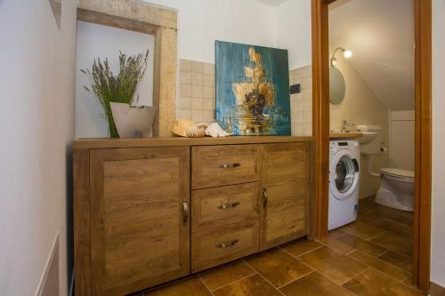 a bathroom with a wooden dresser and a washing machine at Villa Marina Vosteni in Vošteni