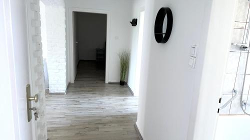 um corredor com paredes brancas e pisos de madeira em Theox Apartment No 8 - 90qm mit 2 Schlafzimmern und 5 Betten em Duisburgo