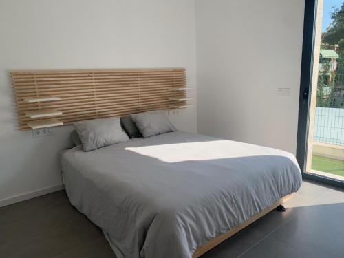 Schlafzimmer mit einem großen Bett mit einem Kopfteil aus Holz in der Unterkunft La Fosca Dream in Palamós