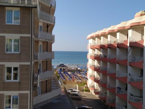 a view of the beach from between two buildings at Hotel Halifax in Lido di Jesolo
