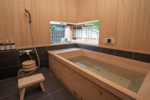 uma grande banheira de madeira na casa de banho em NIPPONIA平福宿場町 em Sayo