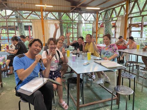 a group of people sitting at tables in a restaurant at De Wang Villa in Meinong