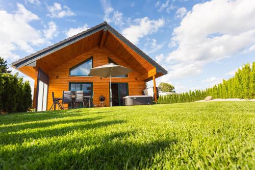 a house on a grassy hill with an umbrella at Chalet Hüttenzauber in Mehlmeisel