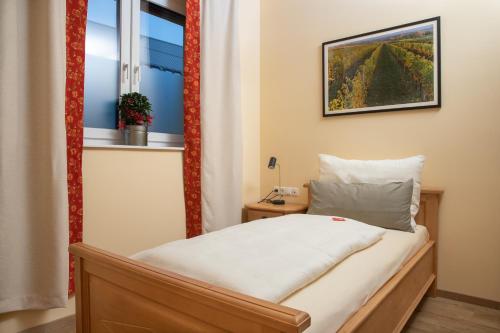 ein kleines Schlafzimmer mit einem Bett und einem Fenster in der Unterkunft Landhaus Storch - Pension in Gänserndorf