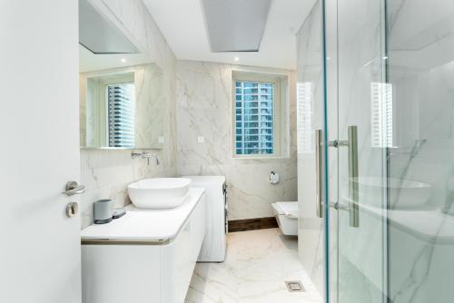 a white bathroom with a sink and a shower at Marina Heights Tower - Vigor Vacations Homes in Dubai