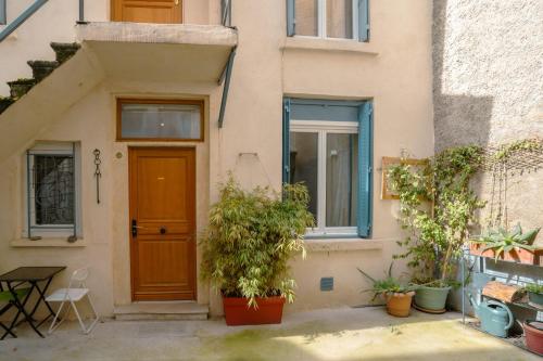 une maison avec une porte marron et quelques plantes dans l'établissement La Petite Cour - Croix-Rousse, Hypercentre, à Lyon