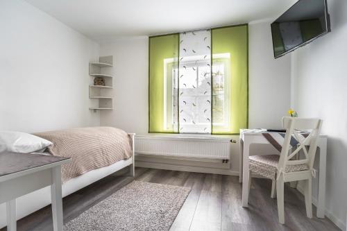 Schlafzimmer mit einem Bett, einem Schreibtisch und einem Fenster in der Unterkunft Apartmentvermietung Ingrid Bolkart - Landleben 6 in Illertissen