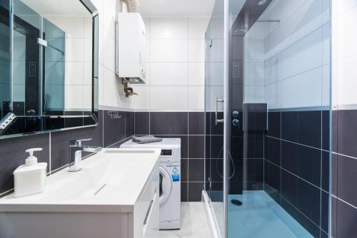 a bathroom with a sink and a shower at Apartament Lelewela in Częstochowa