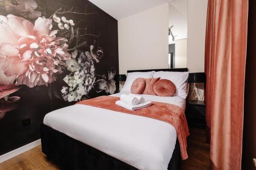 a bedroom with a bed with a flower painting on the wall at ROSE Luxury Apartments in Lublin