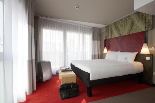 a hotel room with a bed and a large window at ibis Lille Centre Grand Palais in Lille