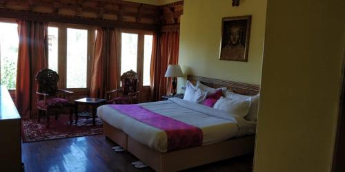 ein Schlafzimmer mit einem Bett in einem Zimmer mit Fenstern in der Unterkunft The Druk Ladakh in Leh