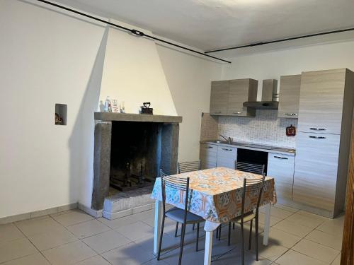 ValfabbricaにあるAgriturismo il Viandanteのキッチン(テーブル、椅子、暖炉付)