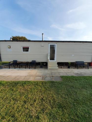a white building with benches in front of it at Fantasy Island King Fisher 8Berth 402 in Ingoldmells