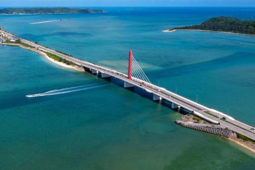 an aerial view of a bridge over the water at 宇堅ビーチまで車で3分 琉球古民家を堪能できる貸切別荘 洋奈月 in Uruma
