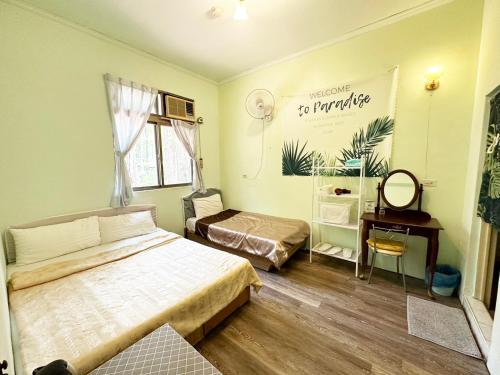 um quarto com 2 camas, uma mesa e um espelho em De Wang Villa em Meinong