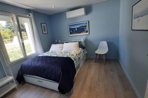 Dormitorio azul con cama y ventana en Villa Quatreal en Provence. Piscine chauffée, en Montségur-sur-Lauzon