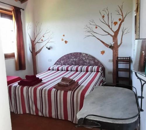 a bedroom with a bed with trees on the wall at Agriturismo Salaiolo 176 in Scansano