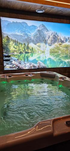 a tv with a bath tub with a large screen at Rezydencja Markowy Dworek in Białka Tatrzanska