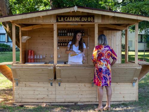 dos mujeres de pie en frente de un puesto de bebidas en Novotel Bordeaux Mérignac, en Mérignac