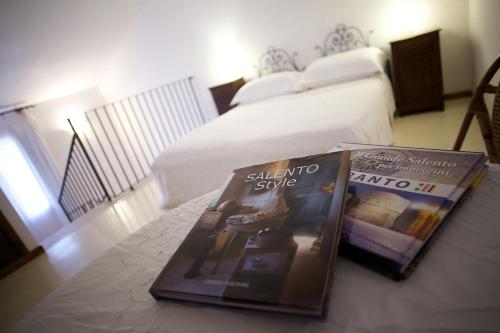 two magazines sitting on a table in a bedroom at Masseria dei Monaci in Otranto