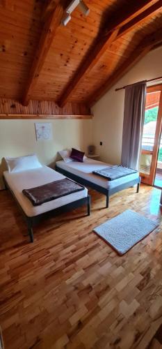 a bedroom with two beds and a wooden ceiling at Apartment TRIO FANTASTICO in Podaca