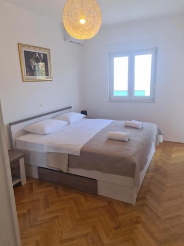 - une chambre avec un lit et 2 serviettes dans l'établissement Apartman Monika, à Marina